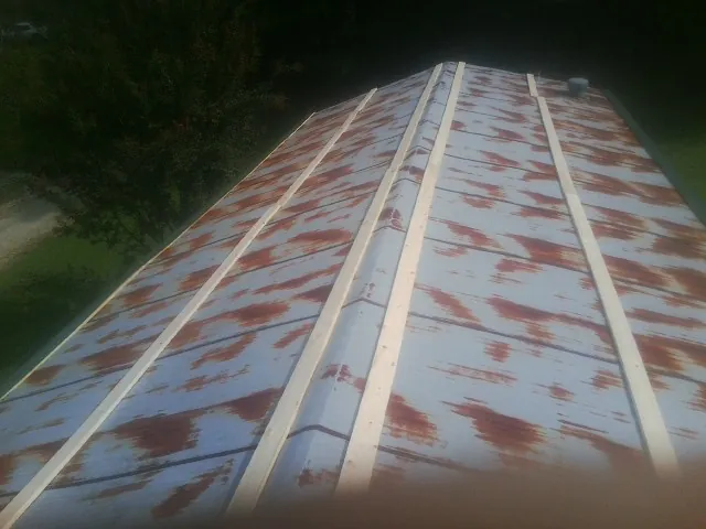 Rusted metal roof panels with new wood purlins before replacement — Storm Damage Roof Repair in Thorndale by Roofing Brothers