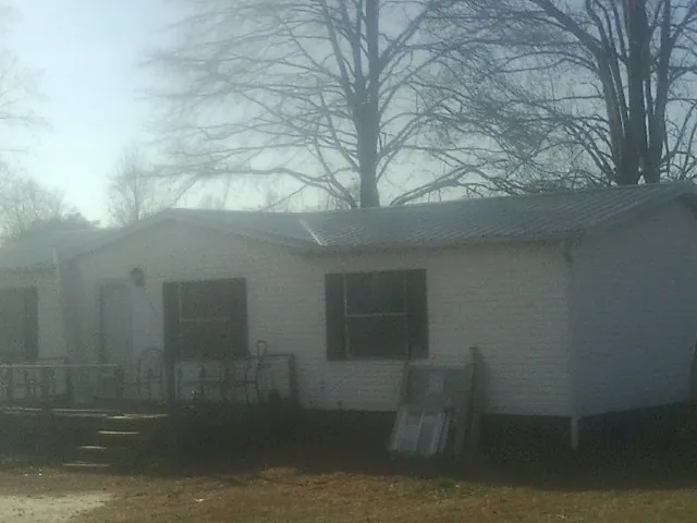 New metal roof on a white painted brick home on a foggy morning in Thorndale