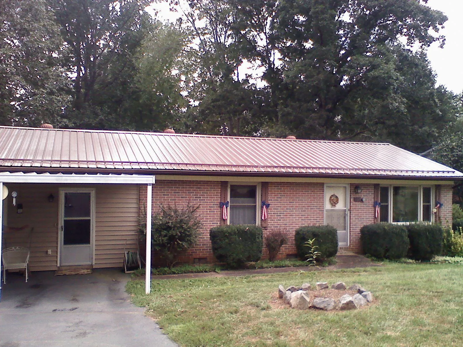 Bronze metal roof and carport on a brick ranch home — Roof Repair work by our crew in Thorndale